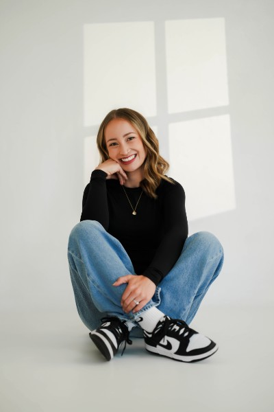 Jenny seated in natural window light, the Lens and Lumina photographer