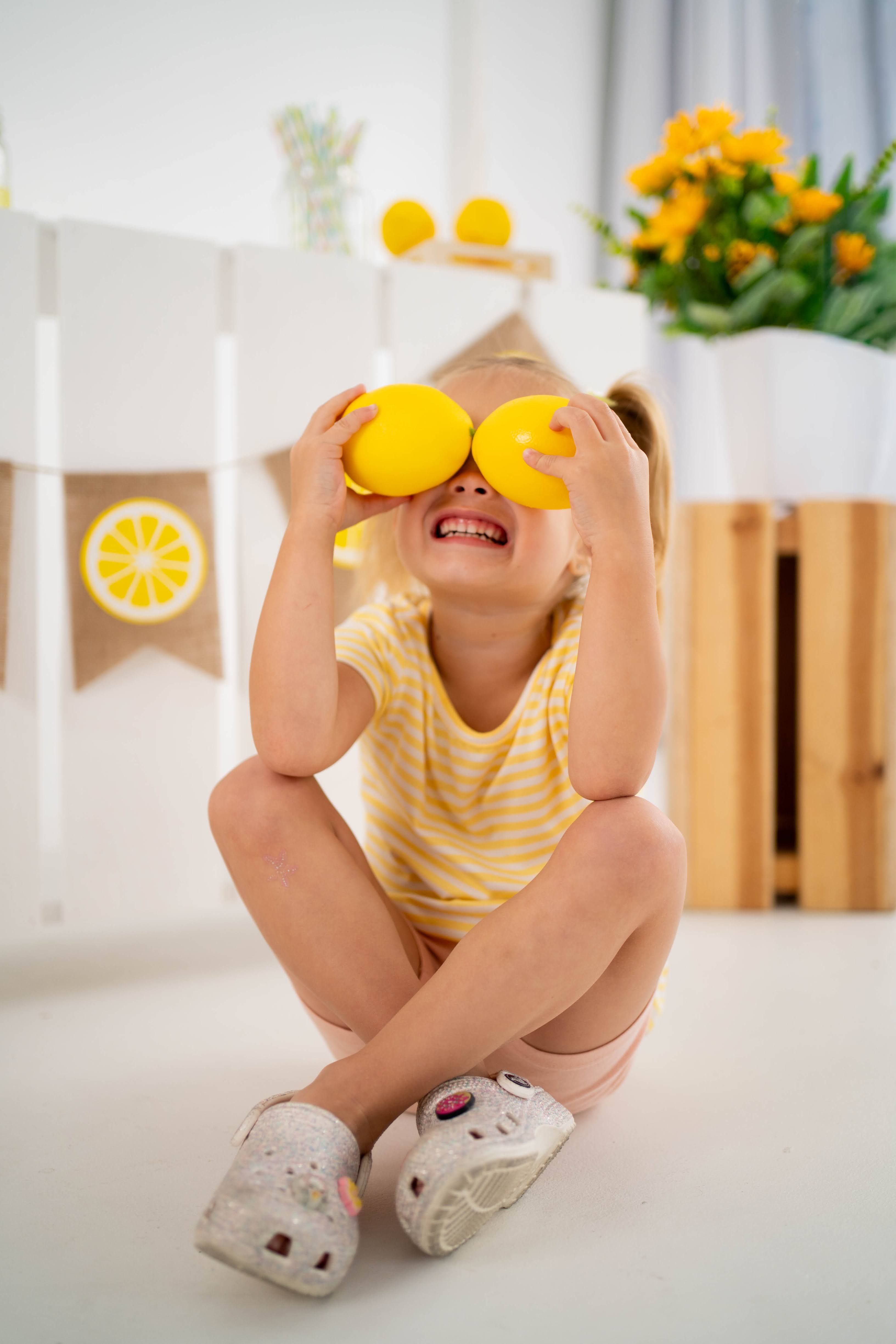 Girl holding a lemonade jar during a bright studio mini session.