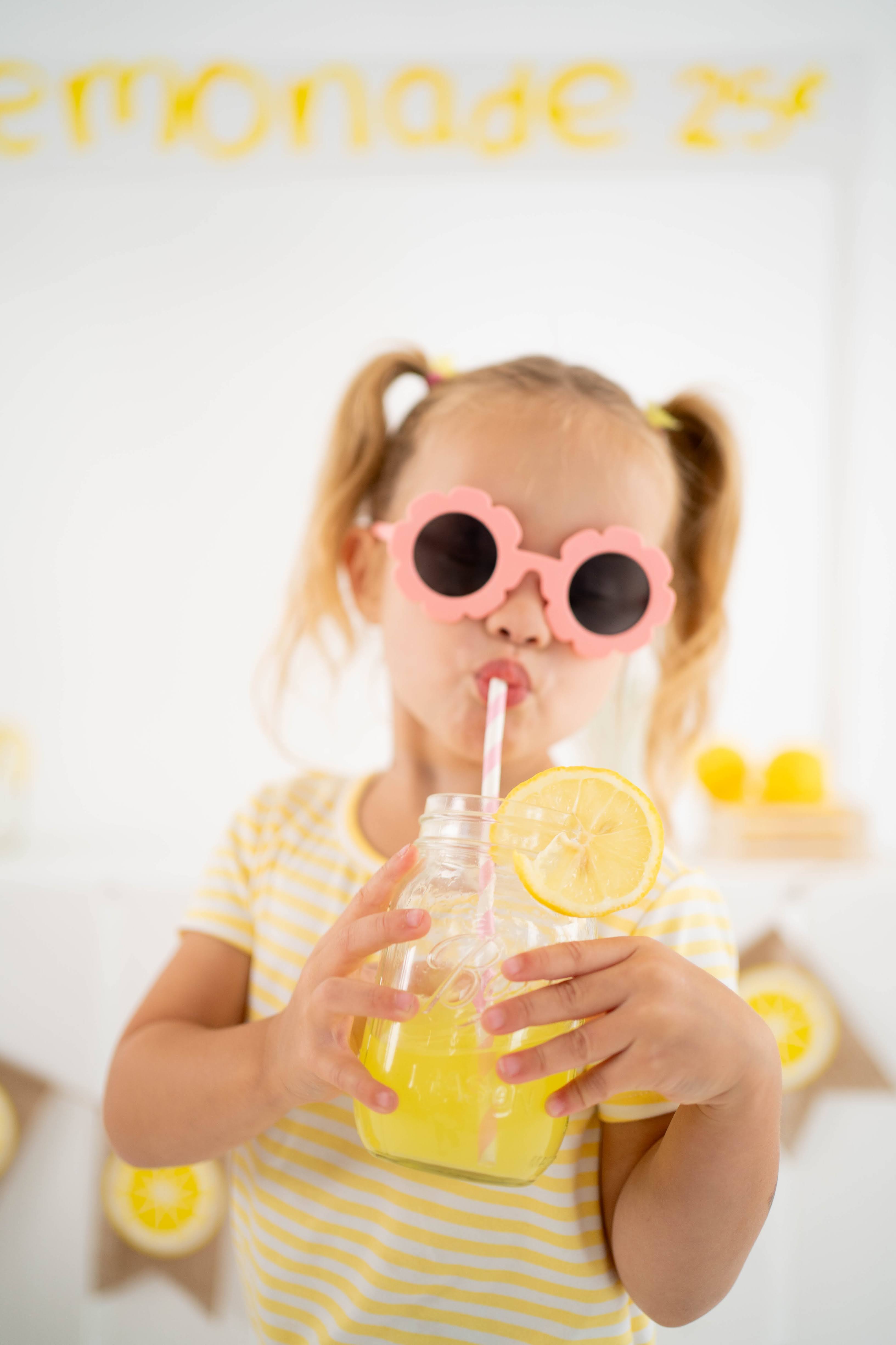 Girl playing with lemonade props in the studio setup.