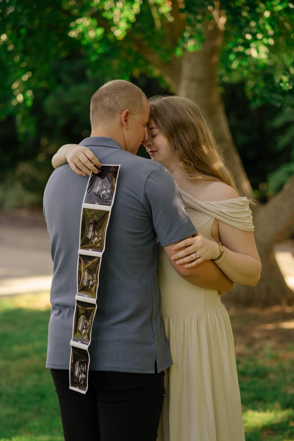 Expecting mother holding her bump in soft outdoor light during a Vacaville maternity session.